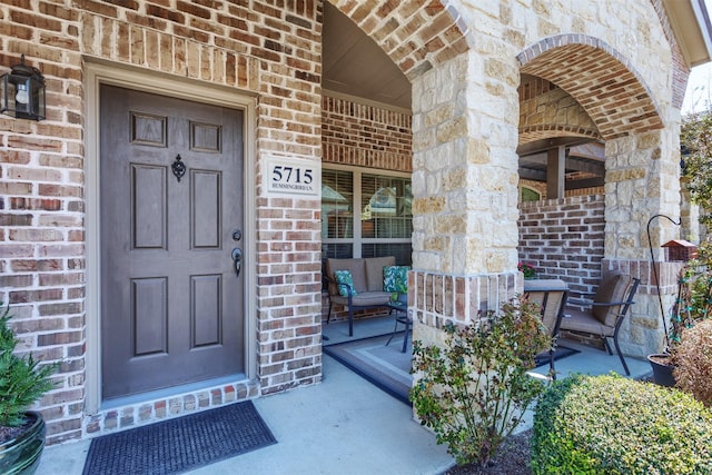 entrance to property with brick siding and covered porch