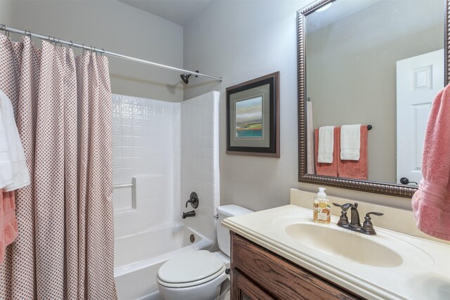 full bath featuring toilet, vanity, and shower / tub combo