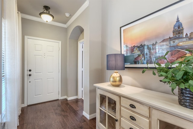 foyer featuring dark wood-style floors, arched walkways, baseboards, and ornamental molding