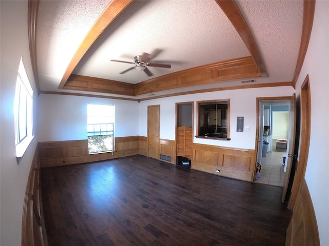 spare room with visible vents, a wainscoted wall, a tray ceiling, dark wood-style flooring, and a textured ceiling