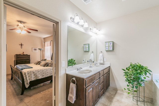 ensuite bathroom with a sink, double vanity, ensuite bath, and a ceiling fan