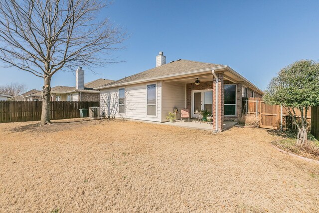 rear view of house with a patio, brick siding, central AC unit, and a fenced backyard