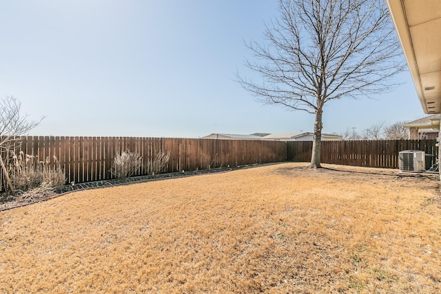 view of yard with central AC and a fenced backyard