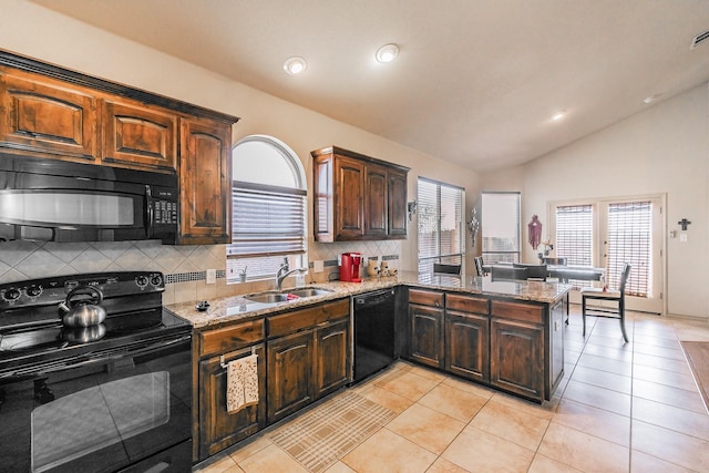 kitchen featuring light stone countertops, vaulted ceiling, light tile patterned flooring, black appliances, and a sink