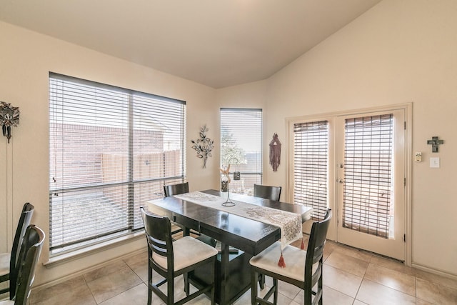 dining area with light tile patterned floors, french doors, and vaulted ceiling