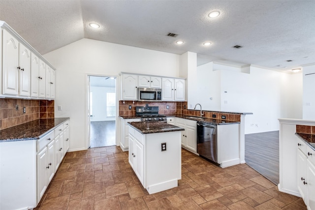 kitchen with visible vents, a peninsula, stainless steel appliances, and a sink