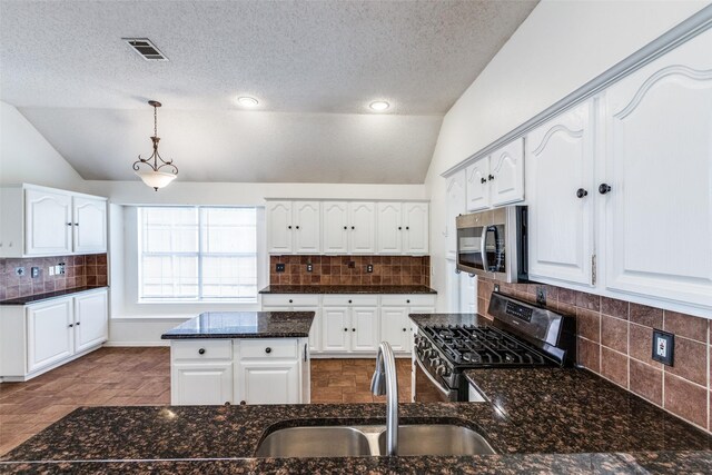 kitchen featuring stainless steel appliances, tasteful backsplash, visible vents, and vaulted ceiling