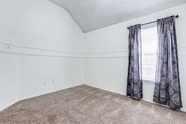 empty room featuring carpet flooring, a healthy amount of sunlight, a textured ceiling, and vaulted ceiling