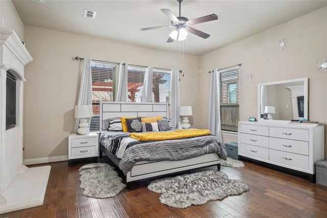 bedroom featuring visible vents, baseboards, a ceiling fan, and hardwood / wood-style flooring