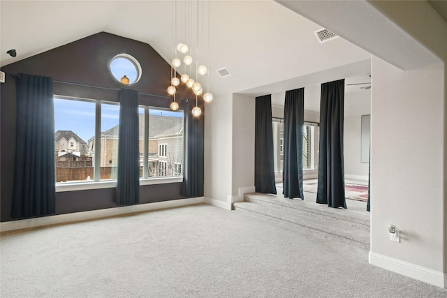 spare room featuring lofted ceiling, baseboards, visible vents, and carpet floors