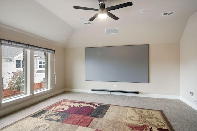 cinema room featuring visible vents, carpet floors, baseboards, and vaulted ceiling