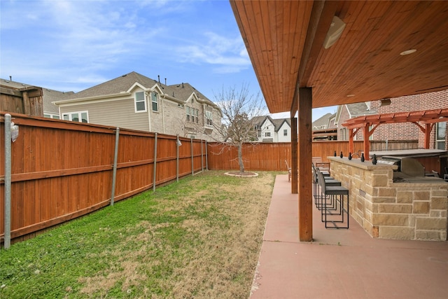 view of yard featuring a fenced backyard, a pergola, a patio area, a residential view, and outdoor dry bar