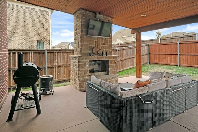 view of patio / terrace featuring an outdoor living space with a fireplace and a fenced backyard