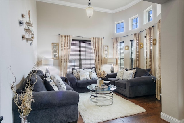 living room featuring a wealth of natural light, crown molding, dark wood-type flooring, and a high ceiling