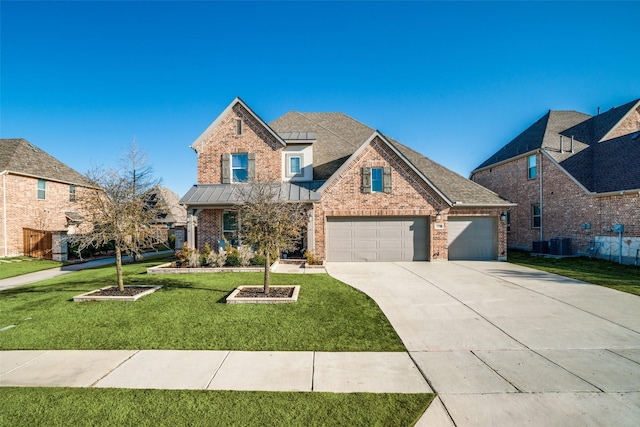 traditional-style home featuring a front lawn, a standing seam roof, roof with shingles, concrete driveway, and brick siding