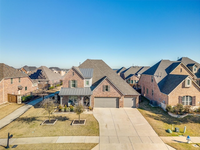 view of front of property featuring brick siding, a front yard, metal roof, driveway, and a standing seam roof