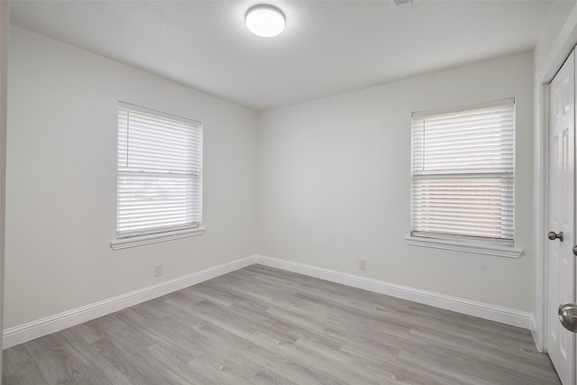 empty room with baseboards and light wood-style floors