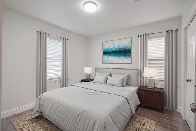 bedroom featuring multiple windows, wood finished floors, and baseboards