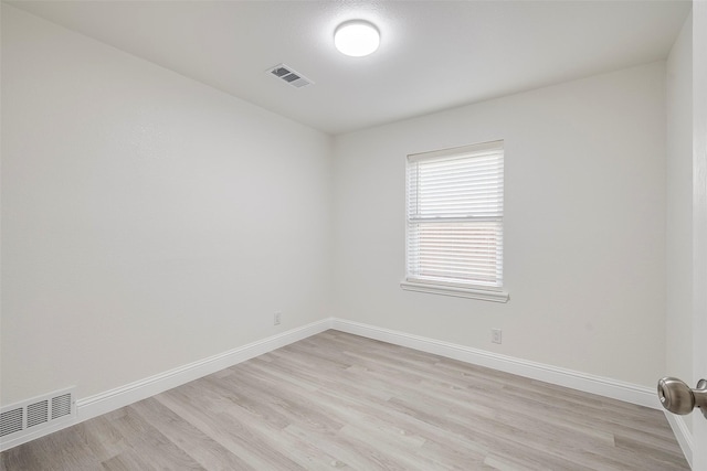 unfurnished room with baseboards, visible vents, and light wood finished floors