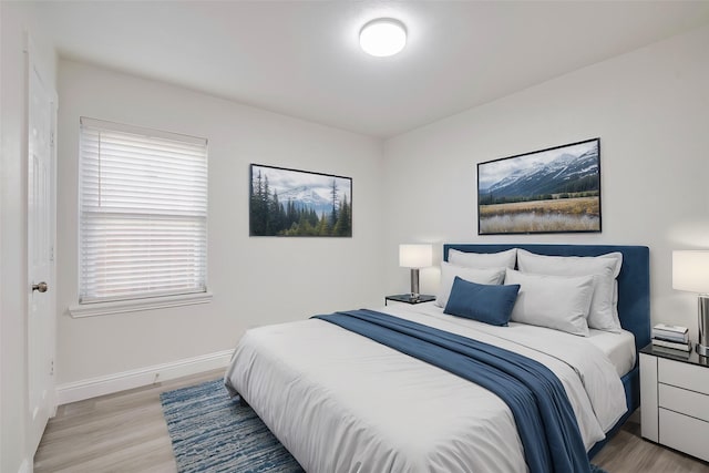 bedroom featuring baseboards and light wood-style flooring