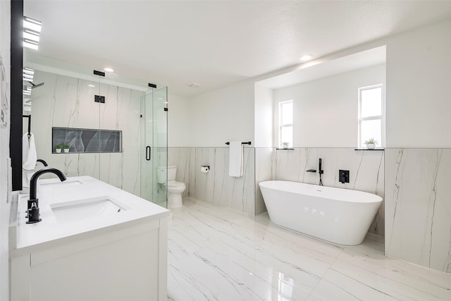 full bath with wainscoting, marble finish floor, a marble finish shower, and a sink