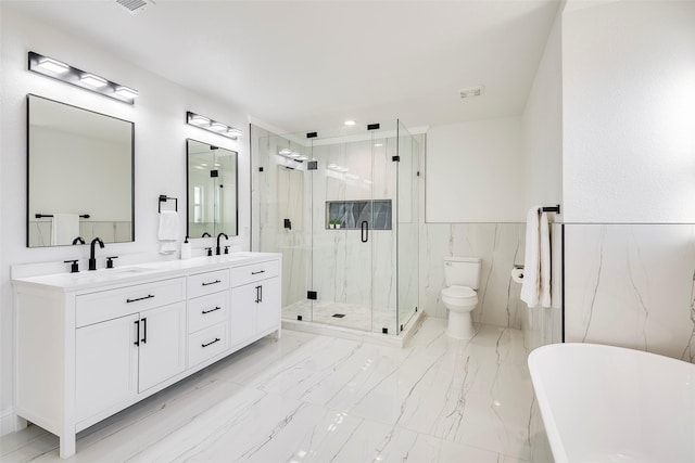 bathroom with a marble finish shower, a freestanding bath, double vanity, marble finish floor, and a sink