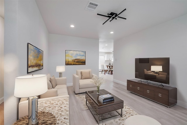 living room with recessed lighting, visible vents, light wood-style flooring, and baseboards