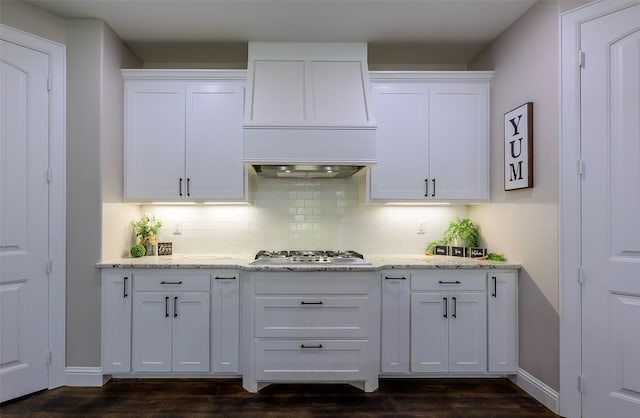 kitchen with white cabinetry, tasteful backsplash, light stone countertops, and stainless steel gas cooktop