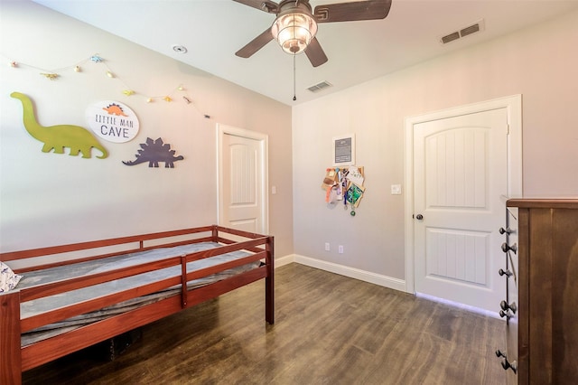 bedroom featuring a ceiling fan, wood finished floors, visible vents, and baseboards