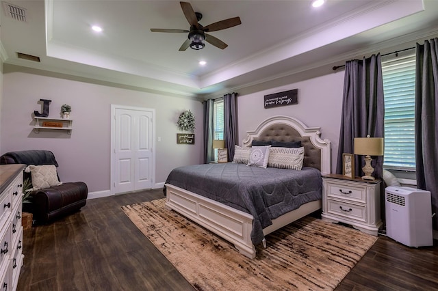 bedroom featuring baseboards, visible vents, dark wood-style flooring, ornamental molding, and a raised ceiling