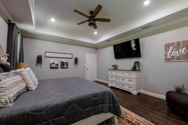 bedroom featuring visible vents, a tray ceiling, dark wood-style floors, crown molding, and baseboards