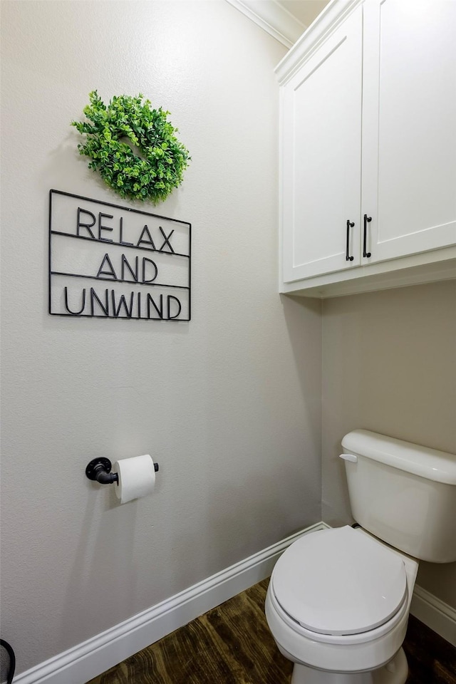 bathroom with baseboards, toilet, and wood finished floors