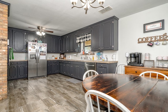 kitchen featuring visible vents, light countertops, ceiling fan with notable chandelier, gray cabinets, and stainless steel appliances