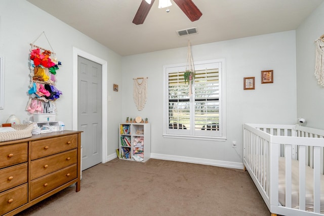 bedroom with visible vents, light carpet, a nursery area, and baseboards