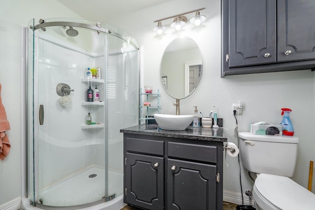 bathroom featuring toilet, a stall shower, and vanity