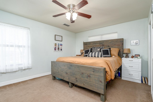 bedroom with light carpet, visible vents, a ceiling fan, and baseboards