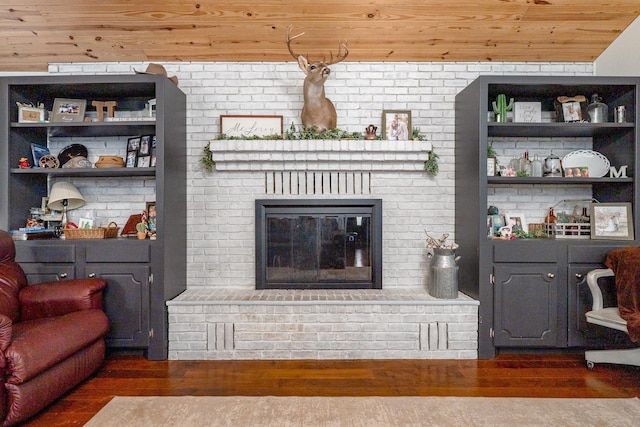 living room featuring wooden ceiling, a brick fireplace, and wood finished floors