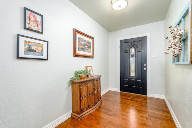 entrance foyer featuring baseboards and wood finished floors