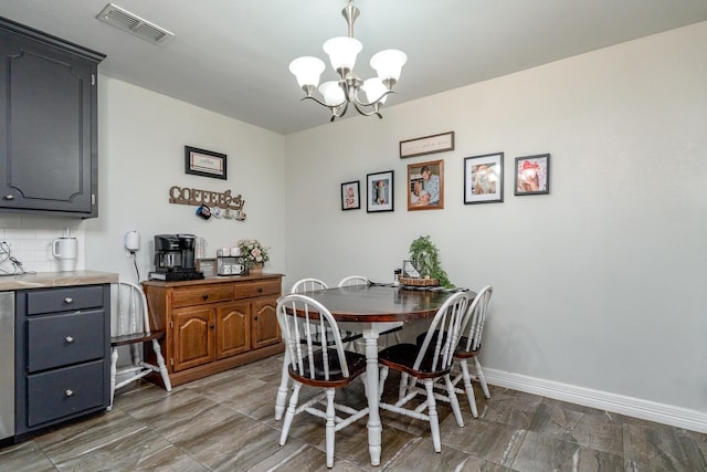 dining area featuring visible vents, baseboards, and an inviting chandelier