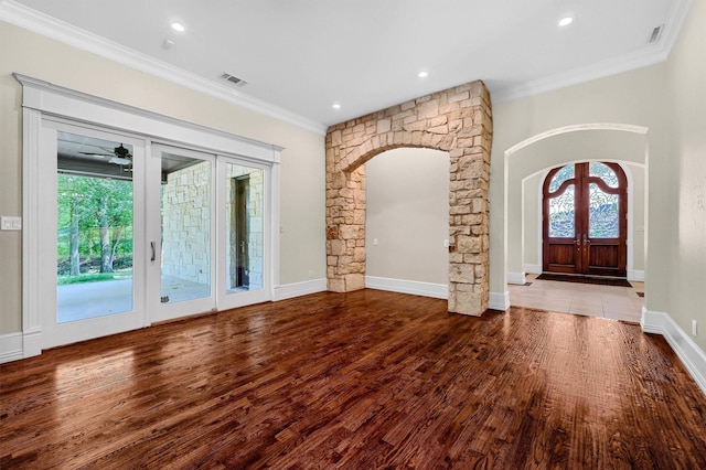 entrance foyer featuring wood finished floors, visible vents, arched walkways, french doors, and crown molding