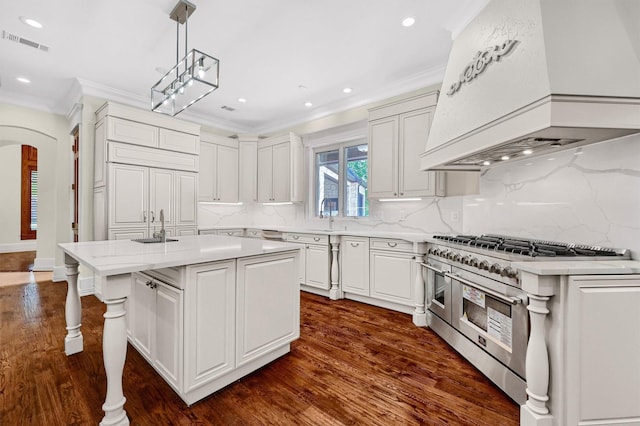 kitchen with visible vents, crown molding, range with two ovens, arched walkways, and custom exhaust hood