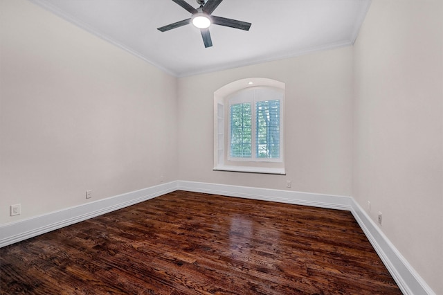 empty room featuring baseboards, crown molding, ceiling fan, and dark wood-style flooring