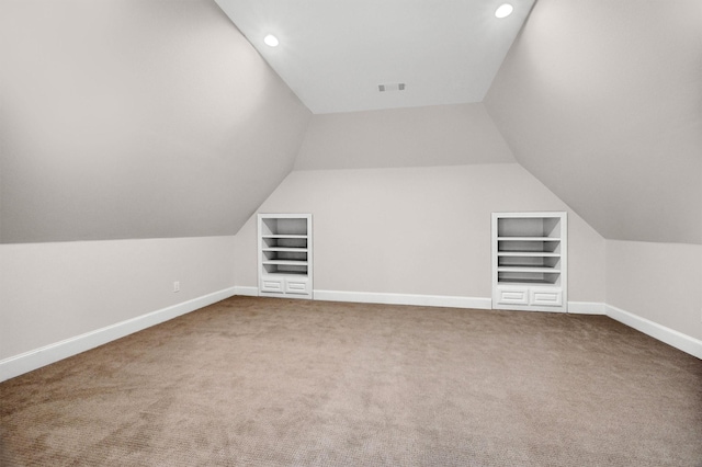 additional living space featuring built in shelves, carpet, and baseboards