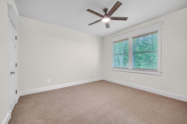 carpeted empty room featuring baseboards and ceiling fan