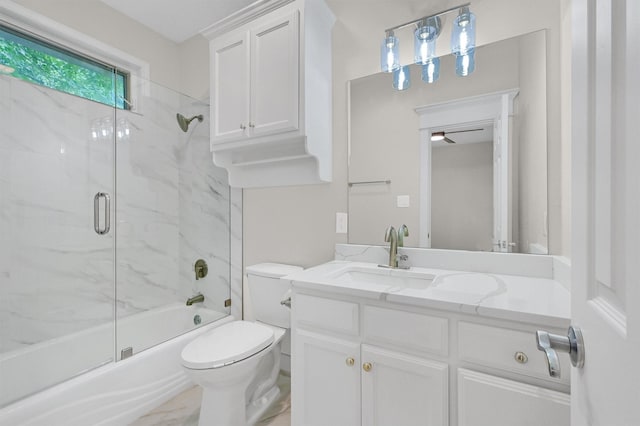 bathroom with enclosed tub / shower combo, toilet, marble finish floor, and vanity