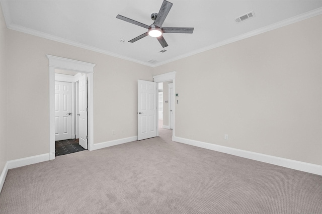 unfurnished bedroom with visible vents, a ceiling fan, carpet, crown molding, and baseboards