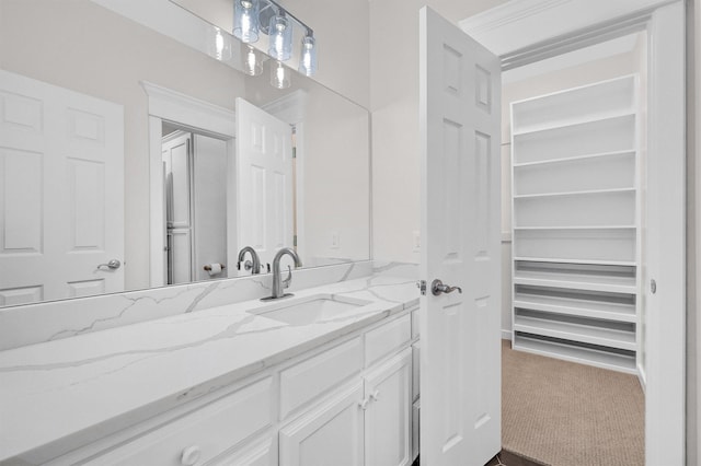 bathroom with a spacious closet and vanity