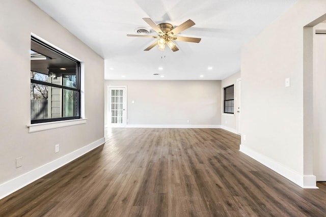 unfurnished room with ceiling fan, visible vents, baseboards, and wood finished floors