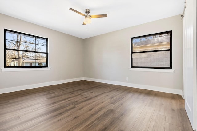 unfurnished room featuring a ceiling fan, baseboards, and wood finished floors