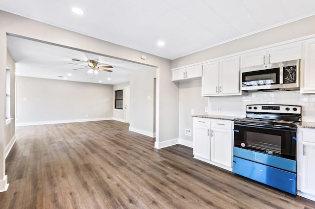 kitchen featuring electric range, stainless steel microwave, backsplash, white cabinetry, and light stone countertops